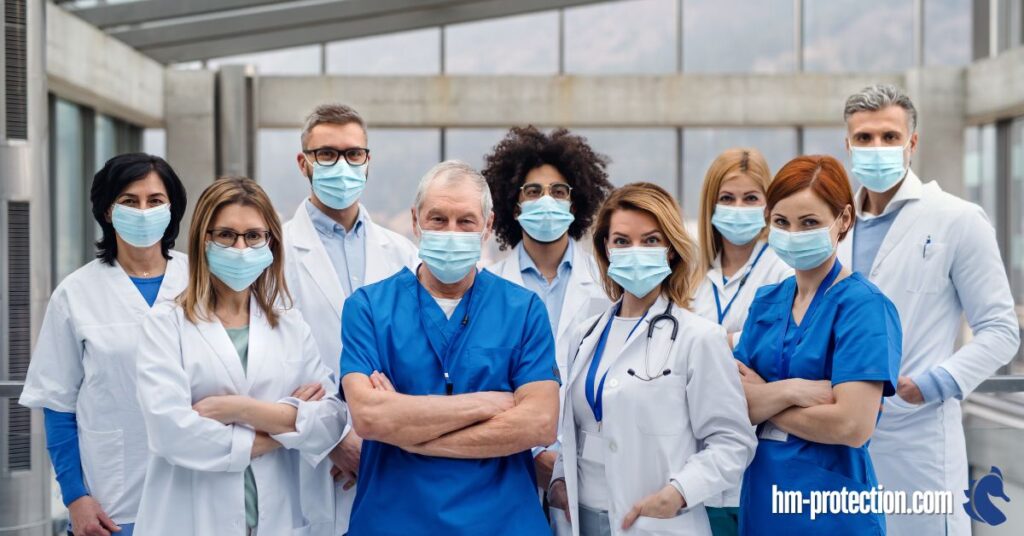 a group of nurses in facemasks looking at the camera being confident