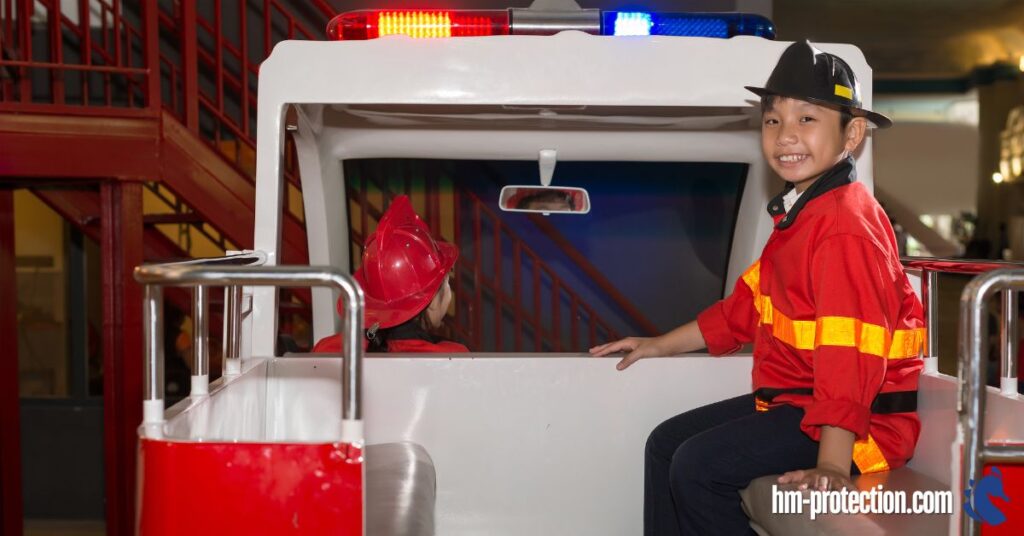 kid being placed on the back of a toy firetruck smiling