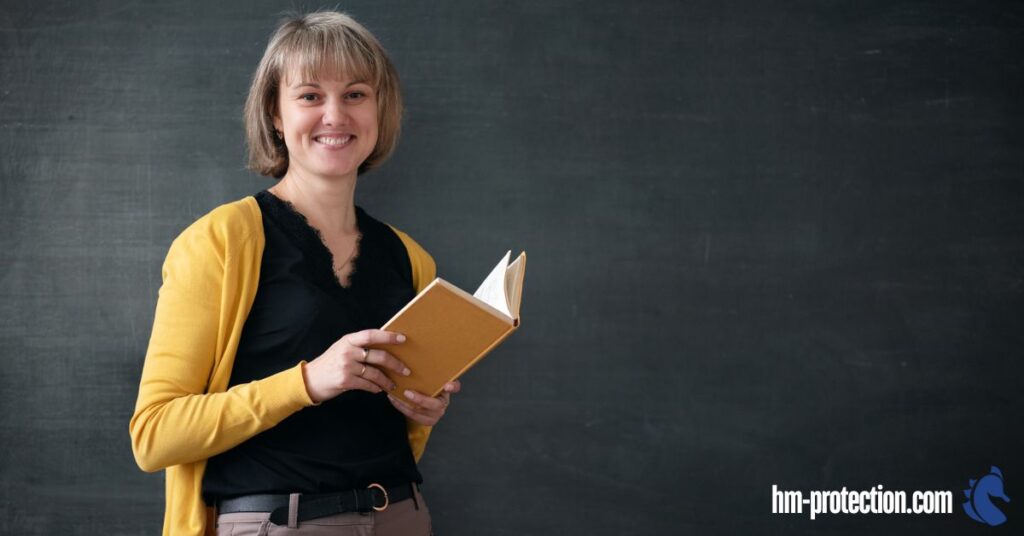 teacher smiling while holding a book